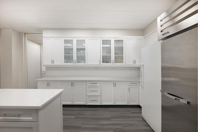 kitchen with white cabinetry, dark hardwood / wood-style floors, and white fridge