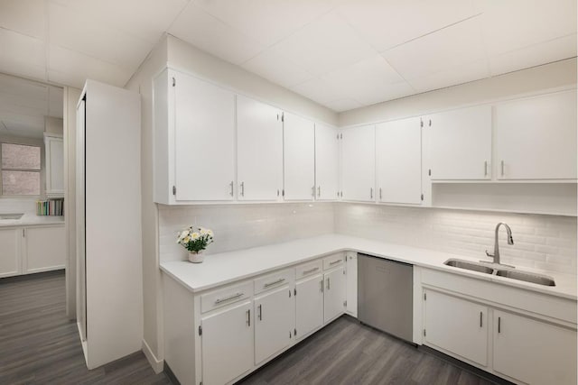 kitchen featuring sink, dark hardwood / wood-style floors, dishwasher, white cabinets, and backsplash