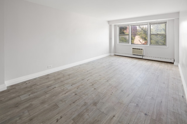 spare room with light wood-style floors, baseboards, and baseboard heating