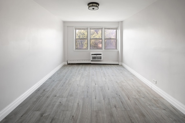 spare room with a wall mounted air conditioner and light hardwood / wood-style flooring