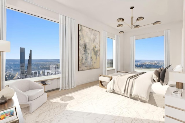 bedroom featuring light wood-type flooring, a notable chandelier, and a city view