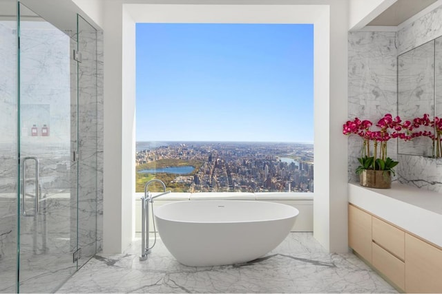 bathroom with a freestanding tub, a city view, a water view, marble finish floor, and a marble finish shower