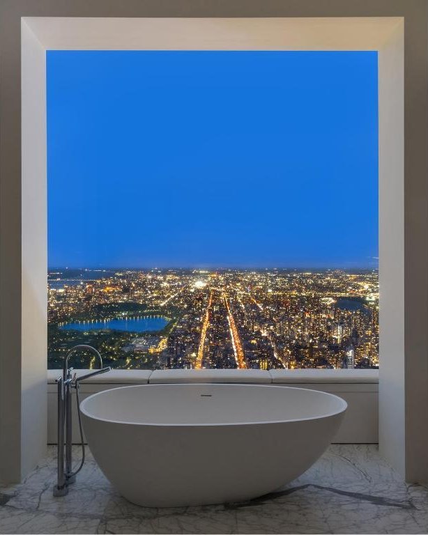 full bath featuring marble finish floor and a soaking tub