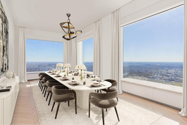 dining space featuring light parquet flooring and a notable chandelier