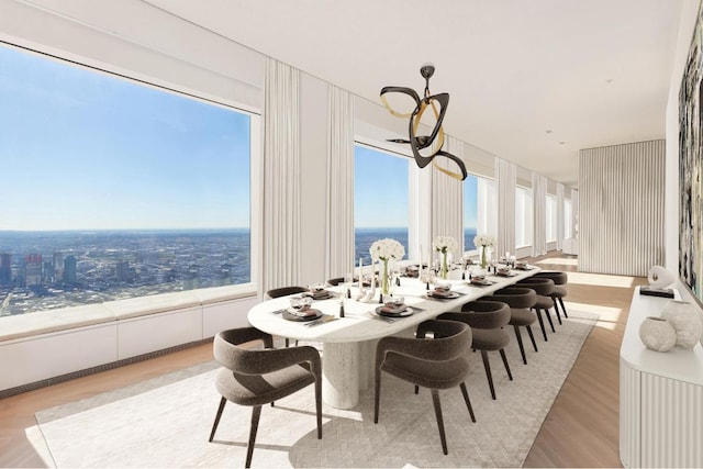 dining area with light wood-type flooring, a water view, and a healthy amount of sunlight