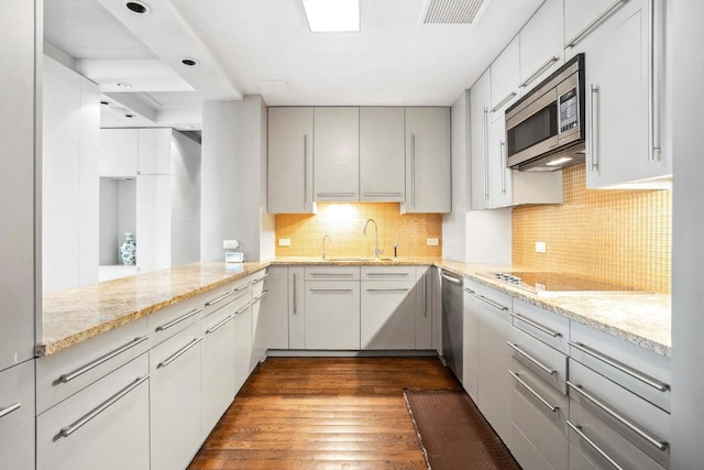 kitchen featuring white cabinetry, appliances with stainless steel finishes, backsplash, dark wood-type flooring, and sink