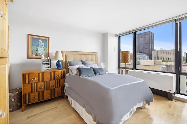 bedroom with light wood-type flooring and radiator heating unit