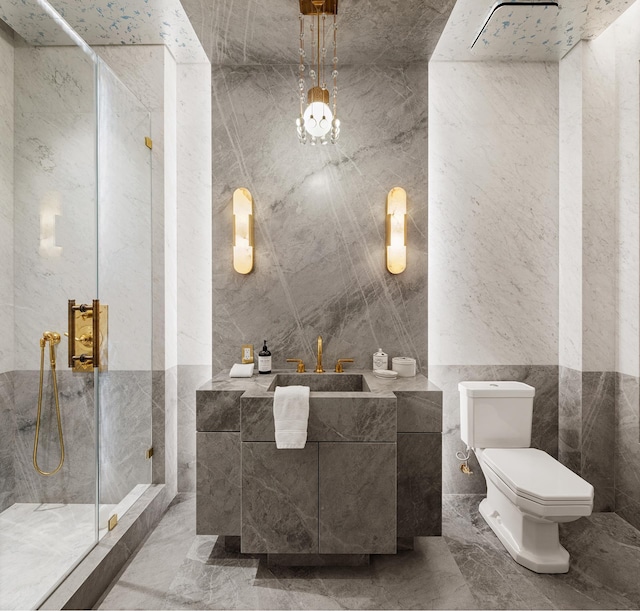 bathroom with a marble finish shower, a sink, toilet, tile walls, and marble finish floor