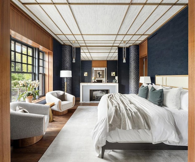 bedroom featuring wood-type flooring and wooden walls