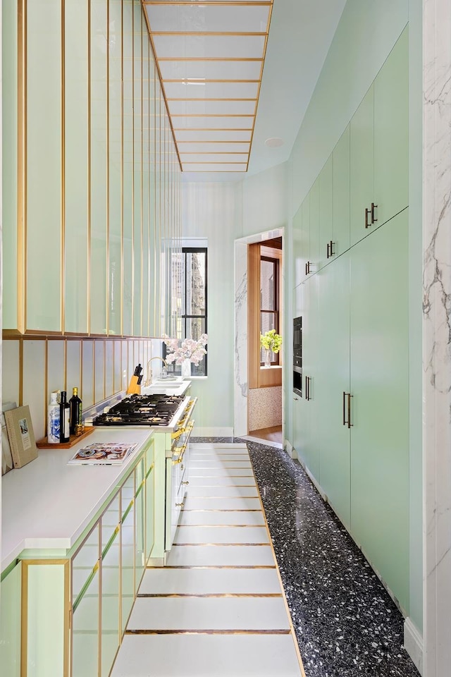 kitchen featuring green cabinetry, light countertops, and high end white range oven