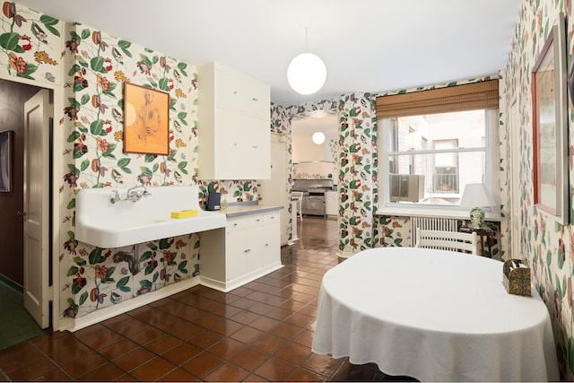 dining room with radiator heating unit, wallpapered walls, and dark tile patterned floors