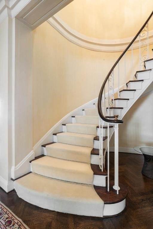 stairs with ornamental molding and parquet flooring