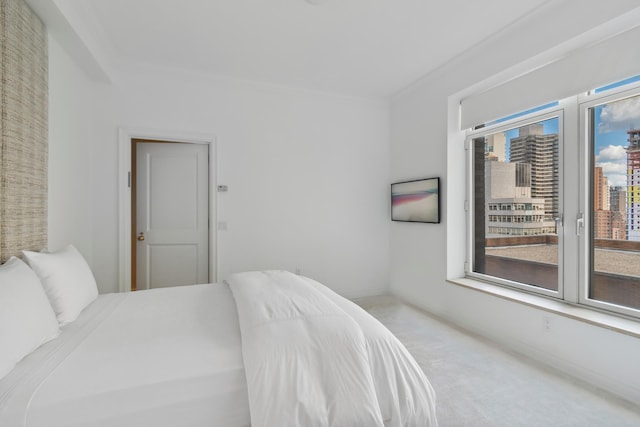 carpeted bedroom featuring access to exterior, baseboards, and crown molding