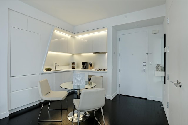 dining space featuring baseboards and dark wood finished floors