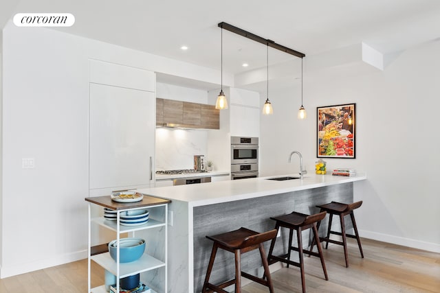 kitchen featuring a breakfast bar, modern cabinets, a sink, and visible vents