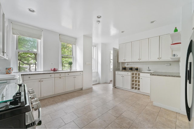1 E End Ave Unit 3C, New York City, NY 10075 - kitchen with open shelves, stainless steel range with gas cooktop, backsplash, white cabinetry, and recessed lighting