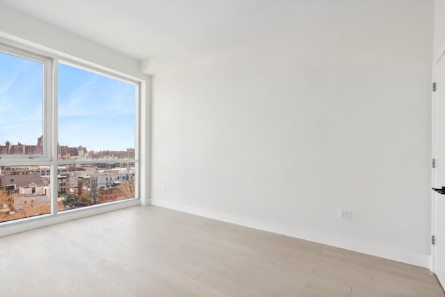139 Bowery Unit 12B, New York City, NY 10002 - spare room with wood finished floors, a view of city, and healthy amount of natural light