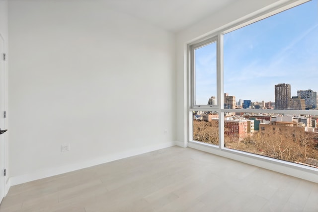 139 Bowery Unit 12B, New York City, NY 10002 - empty room featuring a skyline view and baseboards