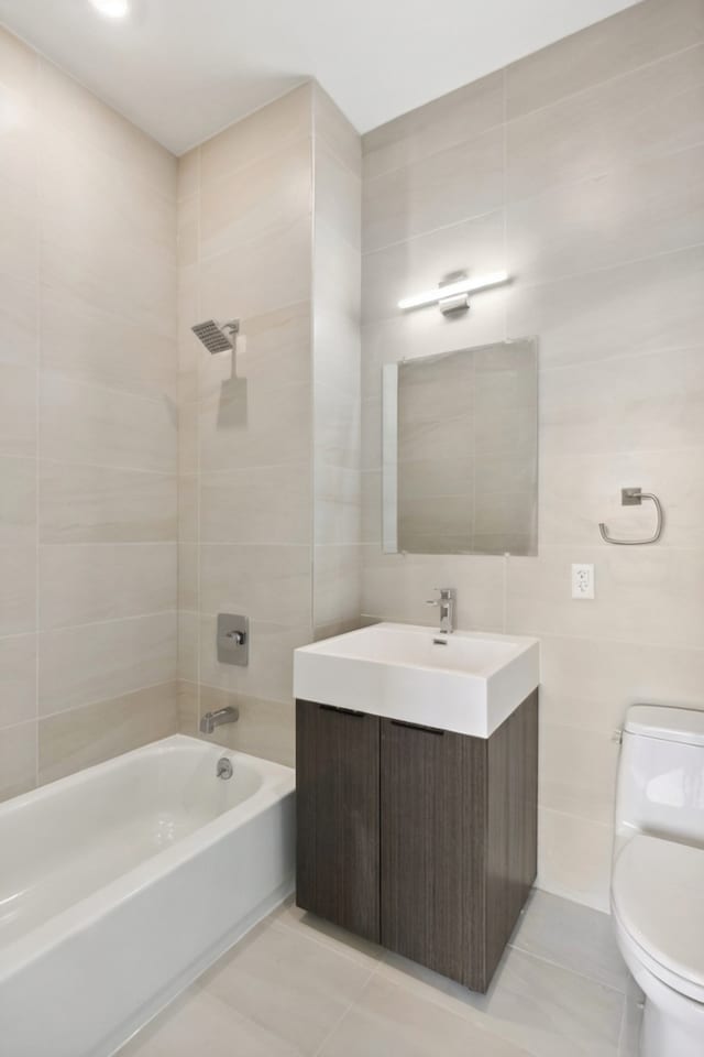 139 Bowery Unit 12B, New York City, NY 10002 - bathroom with vanity, tile walls, bathing tub / shower combination, and tile patterned flooring