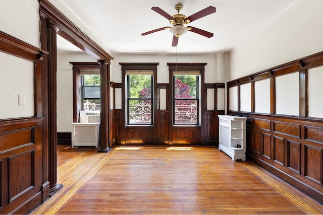 foyer entrance featuring wainscoting, plenty of natural light, light wood-style flooring, and ceiling fan