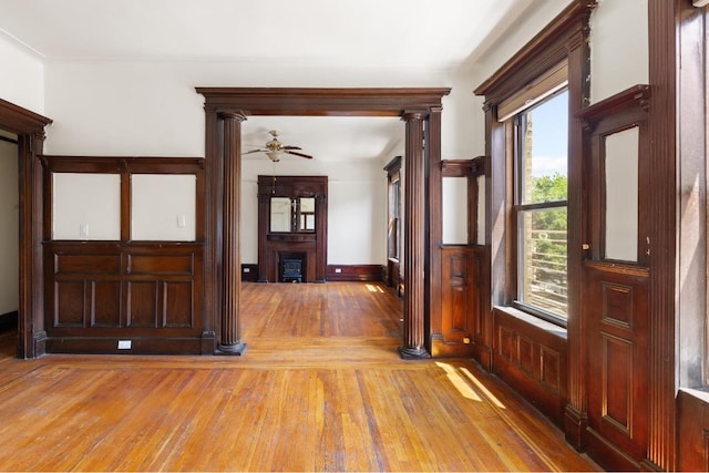 entrance foyer with light hardwood / wood-style floors, decorative columns, and ceiling fan