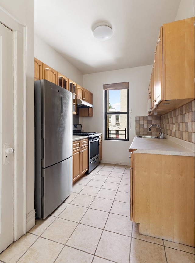 kitchen featuring appliances with stainless steel finishes, light tile patterned flooring, a sink, and under cabinet range hood