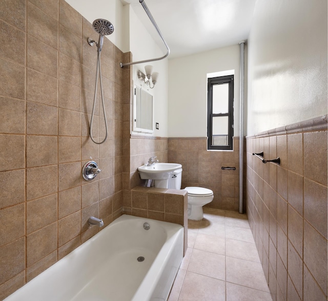 full bath featuring toilet, a wainscoted wall, tile patterned floors, shower / washtub combination, and tile walls