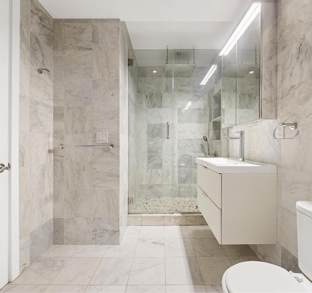 bathroom with an enclosed shower, vanity, toilet, and tile walls