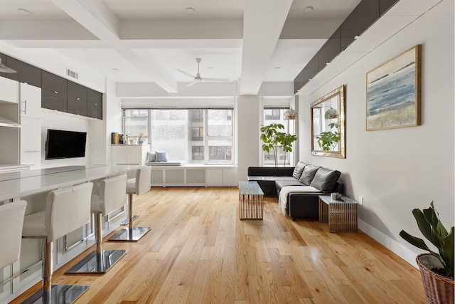 living room with coffered ceiling, a ceiling fan, baseboards, light wood-style floors, and beam ceiling