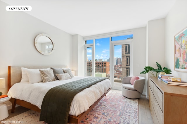 bedroom with light wood-type flooring and access to exterior