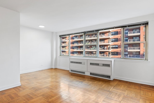 233 E 70th St Unit 10T, New York City, NY 10021 - spare room with radiator heating unit and recessed lighting