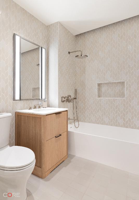 full bathroom featuring vanity, tiled shower / bath, tile patterned floors, and toilet