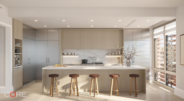 kitchen featuring sink, an island with sink, and a breakfast bar area