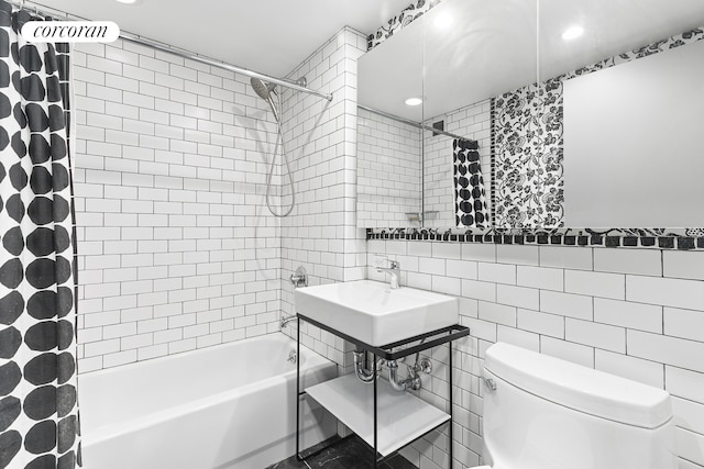 bathroom featuring toilet, tile walls, and shower / tub combo