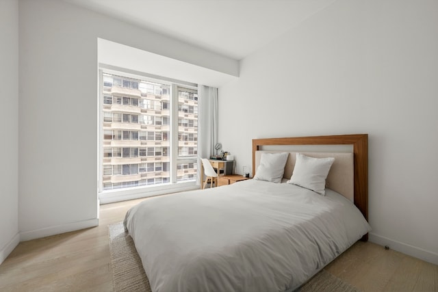 bedroom featuring multiple windows and light wood-type flooring