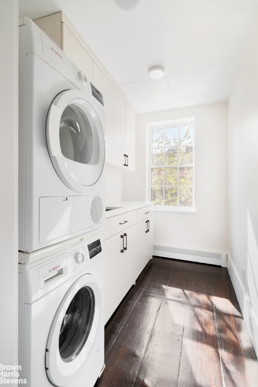 laundry room with dark wood-type flooring, cabinets, and stacked washing maching and dryer