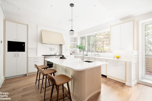 kitchen featuring white cabinetry, custom exhaust hood, and pendant lighting