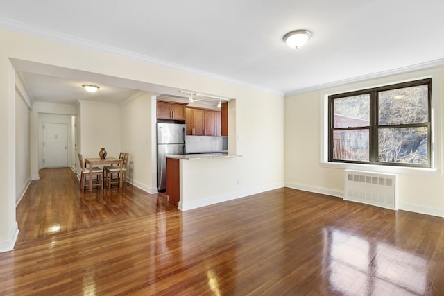 unfurnished living room with ornamental molding, radiator, dark wood finished floors, and baseboards