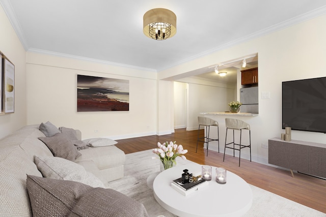 living room featuring crown molding, baseboards, and wood finished floors