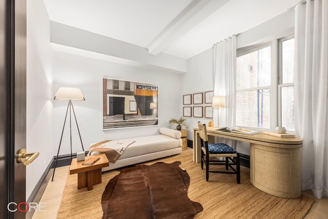 interior space featuring beam ceiling, baseboards, and wood finished floors