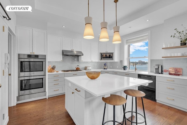 kitchen with a kitchen island, decorative light fixtures, white cabinetry, stainless steel appliances, and a water view