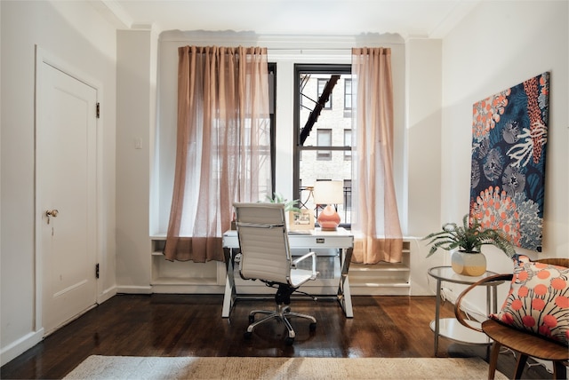 office area with dark wood-type flooring and ornamental molding