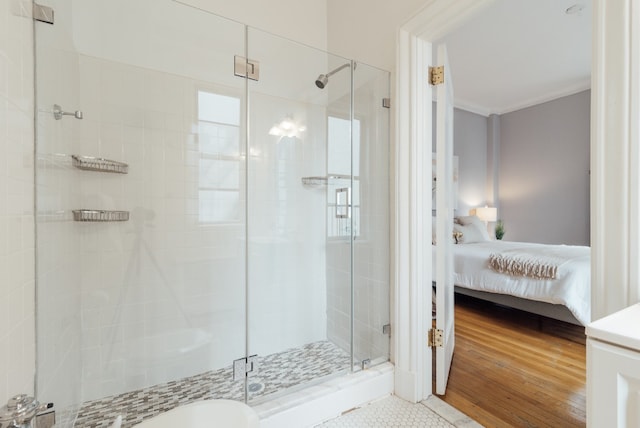 bathroom with a shower with shower door and hardwood / wood-style floors