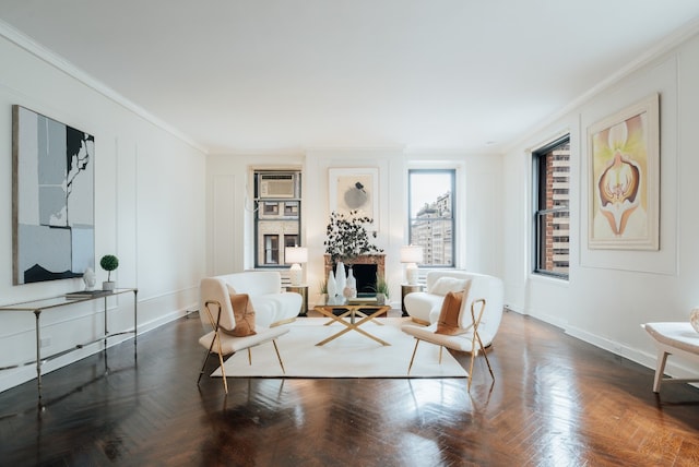 living area featuring crown molding, a fireplace, and dark parquet floors