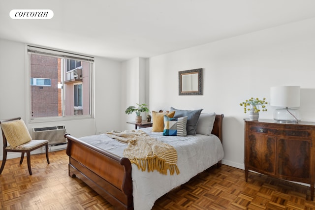 bedroom featuring dark parquet flooring and a wall mounted air conditioner