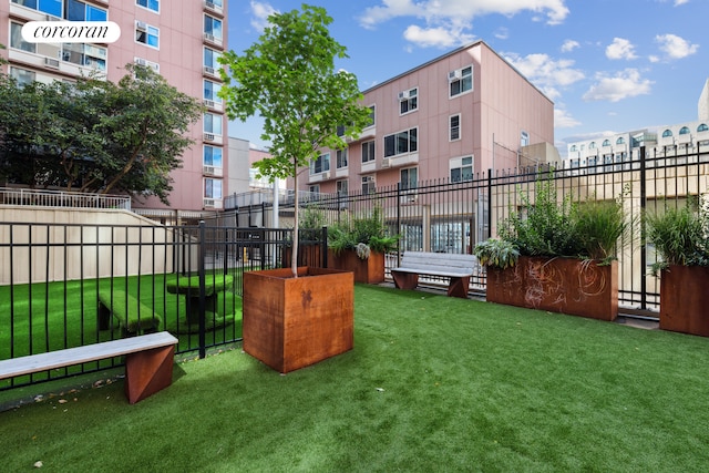 view of property's community featuring a lawn and fence