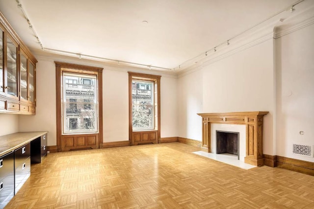 carpeted bedroom with crown molding and track lighting