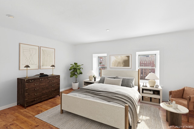 bedroom with light wood finished floors and baseboards