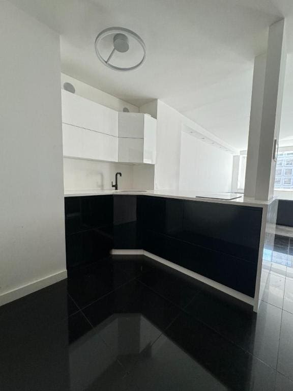 kitchen with sink, white cabinetry, and tile patterned floors