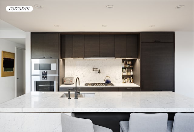 kitchen with a breakfast bar, visible vents, backsplash, appliances with stainless steel finishes, and a sink